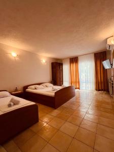 a hotel room with two beds and a television at Villa H&M in Baška Voda