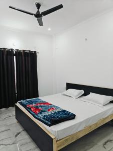 a bed in a room with a ceiling fan at Elegant Non AC Room Near IIM College in Lucknow