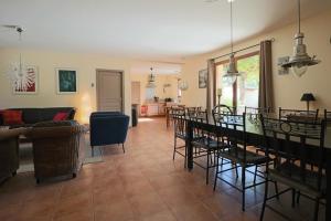 a living room with a couch and a table and chairs at Maison Périgourdine au calme in Saint-Cybranet