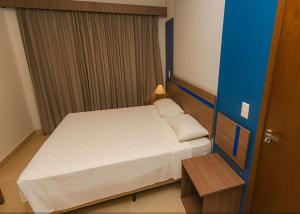 卡达斯诺瓦斯De Souza Apart Hotel Thermas Vista的一间带床和桌子的小卧室