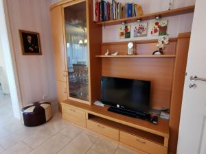 a living room with a tv in a wooden entertainment center at Ferienhaus Mooi Huus 95157 in Rhauderfehn