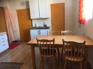 a kitchen with a wooden table and chairs at Hillilän Koulu in Kalajoki +1 photo
