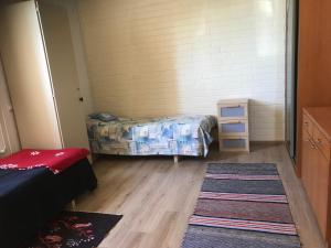a room with two beds and a rug at Hillilän Koulu in Kalajoki