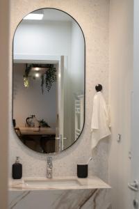 un baño con espejo y lavabo en The Lake Home B1 ap13, en Sibiu