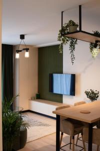 Una sala de estar con un televisor y una mesa. en The Lake Home B1 ap13, en Sibiu