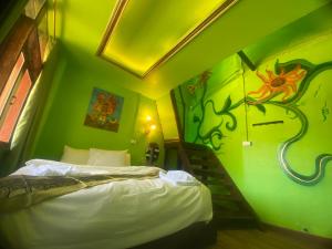 a small room with a bed and a painting on the wall at Valley Yurt rakthai วอลเล่ย์ เยิร์ท รักไทย in Ban Nong Chaeng