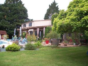 BeaugasLe Pré Joli的一座带游泳池的房子和一座种植了植物的庭院