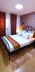 a bedroom with a large bed with white sheets at Sweet Home in Dimona