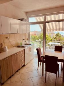 a kitchen with a table and a large window at Villa H&M in Baška Voda