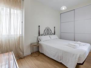 セビリアにあるLanza Tranquilo y acogedorの大きなベッドと窓のある白い寝室