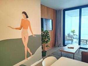 un dibujo de una mujer en una pared en una sala de estar en Wavescape Endless Ocean, en Muizenberg