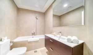 ドバイにあるStunning Sea View 2BR Luxury Apartment in Marinaの洗面台、浴槽、トイレを備えたバスルーム