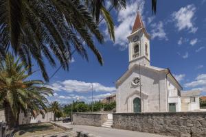 eine Kirche mit einem Turm mit einer Uhr drauf in der Unterkunft Villa Baras garden - house with pool in Mirce