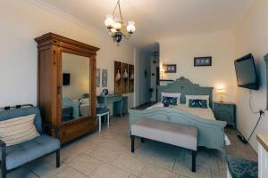 a bedroom with a bed and a chair and a mirror at Hotel Villa Sevasti in Katerini