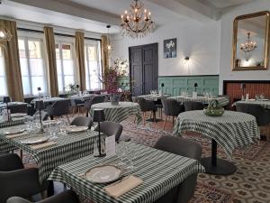 a restaurant with tables and chairs and a chandelier at Hotel Le Normandy in Beaumont-de-Lomagne