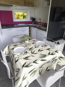 a kitchen with a table with a green and white table cloth at Ty-koad in Laz +3 photos