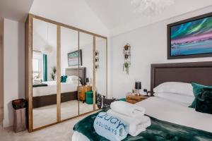 een slaapkamer met twee bedden en een grote spiegel bij Dolce Vita - Duplex Apartment with Incredible Harbour Views in Poole