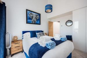 een slaapkamer met een bed met blauwe en witte handdoeken bij Dolce Vita - Duplex Apartment with Incredible Harbour Views in Poole +28 foto's