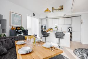 een woonkamer en een keuken met een tafel en stoelen bij Dolce Vita - Duplex Apartment with Incredible Harbour Views in Poole