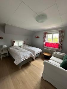 a bedroom with two beds and a couch at B&B Knuss in Öje