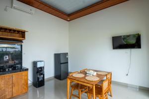 a dining room with a table and a refrigerator at Obah Villa Ubud 1 Br Brand new private villa in Ubud