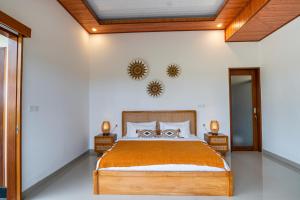 a bedroom with a large bed with orange bedspread at Obah Villa Ubud 1 Br Brand new private villa in Ubud