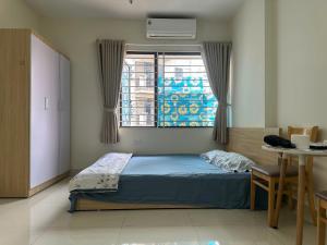 ein Schlafzimmer mit einem Bett und einem Tisch und einem Fenster in der Unterkunft nhatroduytan in Hanoi