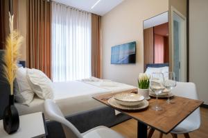 ein Hotelzimmer mit Bett, Tisch und Stühlen in der Unterkunft Gamma Hotel Durres - FREE PARKING & SUNBEDS in Durrës