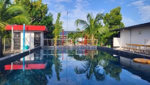 a swimming pool with blue water and palm trees at Bell Farms and Resorts in Munroe Island