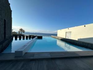 a large swimming pool next to a building at Horizon Luxury Seafront Villa in Vaia