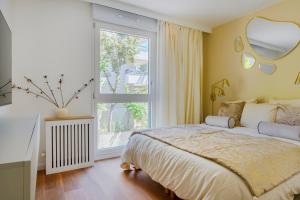 a bedroom with a bed and a large window at Paris West Elegant residence in Suresnes