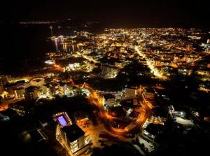 a view of a city at night with lights at Dine Hotel in Ksamil