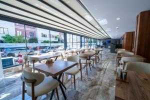 a row of tables and chairs in a restaurant with windows at Coastline Orange Hotel in Antalya