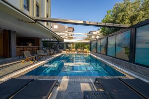 a swimming pool with tables and chairs next to a building at Coastline Orange Hotel in Antalya
