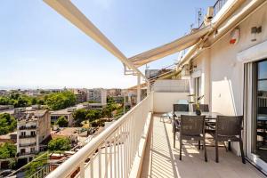 a balcony with a table and chairs and a view at Thessaloniki Gem -1 min from Metro - Brand New Flat with View - Ολοκαίνουργιο Διαμέρισμα Με Θέα!! in Thessaloniki