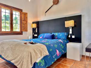 a bedroom with a bed with a blue comforter at Complejo Rural Casas-Cueva La Teja in Cortes de Baza +221 photos