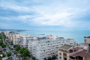 Eine Stadt mit Gebäuden und dem Meer im Hintergrund in der Unterkunft Gamma Hotel Durres - FREE PARKING & SUNBEDS in Durrës