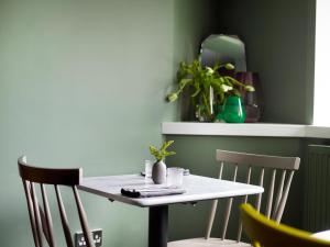 a white table with two chairs in a room at The Royston in Llanbrynmair
