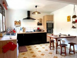 a kitchen with a table and chairs in a room at Villa Kaz K vue sur la mer des Caraibes in Bouillante