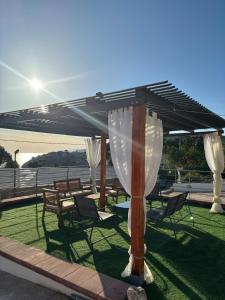a patio with tables and chairs under a pavilion at Acquamarina in Gaeta