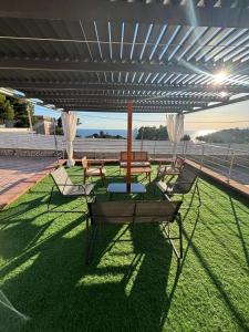 a patio with a table and chairs on the grass at Acquamarina in Gaeta