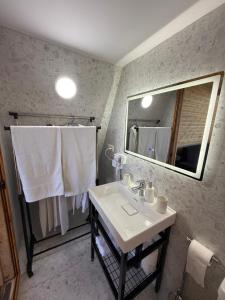 斯库台Alex's House Shirokë的带水槽、镜子和毛巾的浴室