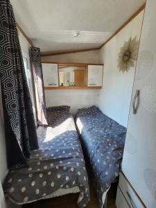 a small bedroom with a bed in a trailer at MOBILHOME camping LA FALAISE in Équihen-Plage +3 photos