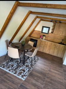 a dining room with a table and chairs on a rug at Vikendica Hamza in Bihać +15 photos