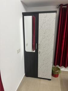a black door with a mirror and red curtains at Cozy Glick in Varkala