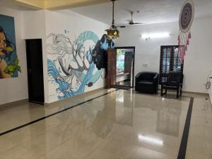 a lobby with a large painting on the wall at Cozy Glick in Varkala +3 photos