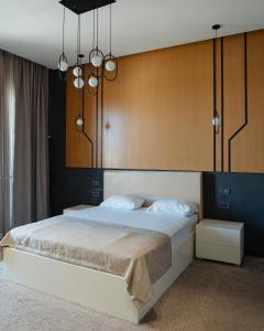 a bedroom with a large bed with a wooden headboard at Shani Resort Hotel & Villas in Mardakan
