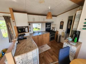 a kitchen with wooden cabinets and a counter top at MOBILHOME camping LA FALAISE in Équihen-Plage