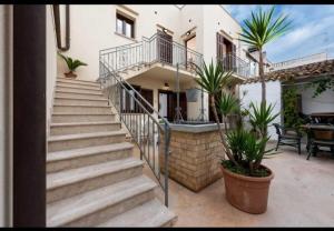 a staircase leading up to a house with potted plants at SanVitoTour - Covo deI Pirati in San Vito lo Capo