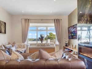 a living room with a couch and a large window at Newly Renovated Luxury Bungalow Pass the Keys in Ulverston